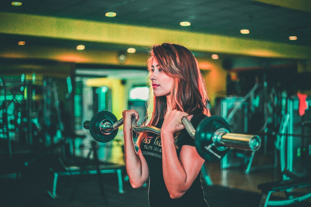 Description: woman lifting black and gray barbell